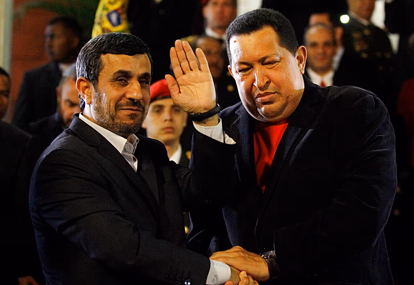 FÁJLOK: Mahmúd Ahmadinezsád iráni elnök integet, miközben kezet fog Hugo Chavez venezuelai elnökkel a caracasi Miraflores elnöki palotában, 2012. június 22.