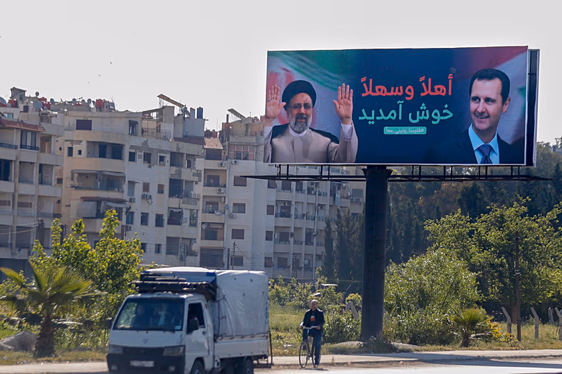 FÁJL: Autók haladnak el egy plakát alatt, amelyen Ebrahim Raisi iráni elnök és Bassár el-Aszad szíriai elnök arabul „Üdvözöljük” feliratú képei láthatók Damaszkuszban, 2023. május 3.