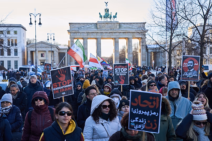 A tüntetők részt vesznek a berlini Brandenburgi kapu előtti tüntetésen, 2026. január 11-én