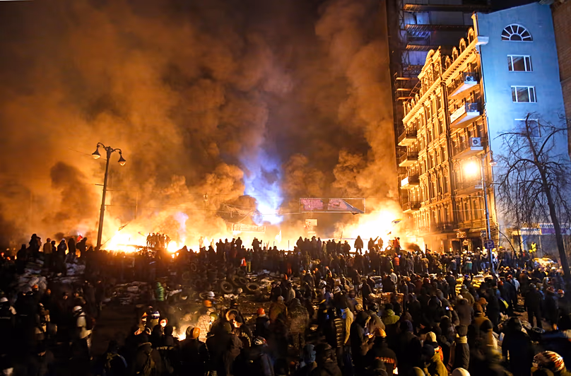 Füst és tűzgolyók emelkednek a tüntetők és a rendőrség közötti összecsapások során Kijev központjában, 2014. január 25.