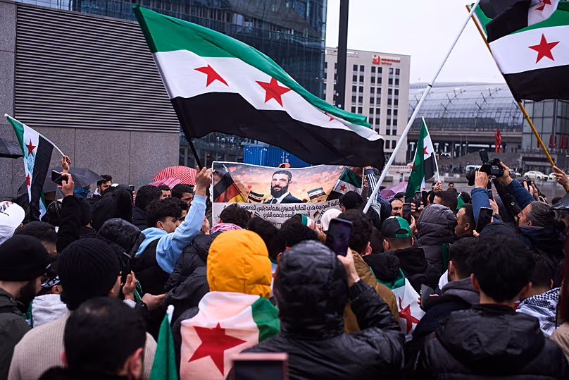 Az Ahmad al-Sharaa szíriai elnököt támogató emberek ünnepelnek a berlini kancelláriával szemben Friedrich Merz német kancellárral való találkozó előtt, 2026. március 30.