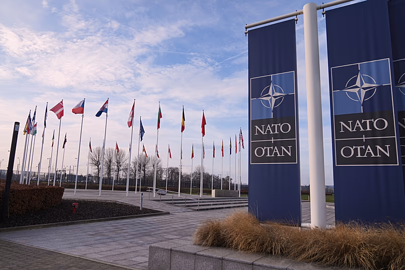 Zászlók lobognak a szélben a NATO brüsszeli központja előtt, 2026. január 19