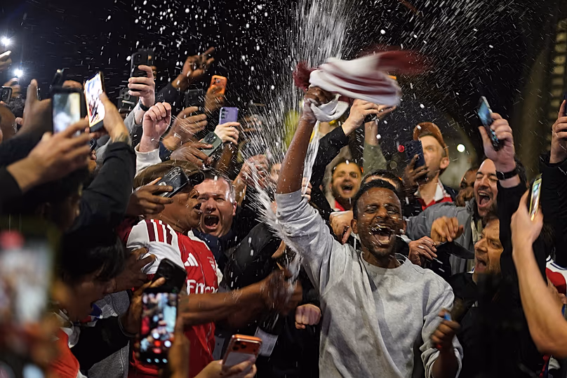 Az Arsenal-szurkolók ünnepelni gyűlnek össze az Arsenal stadionban, miután az Arsenal labdarúgócsapata megnyerte a Premier League címet Londonban, 2026. május 19-én, kedden.