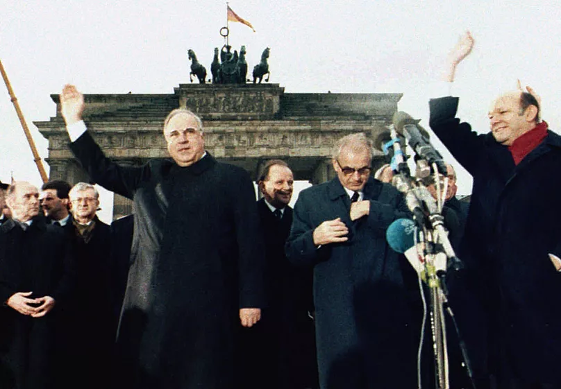 West German chancellor Helmut Kohl, left, stands together with then East German Prime Minister Hans Modrow, second right, in front of the Brandenburg Gate, Dec. 22. 1989