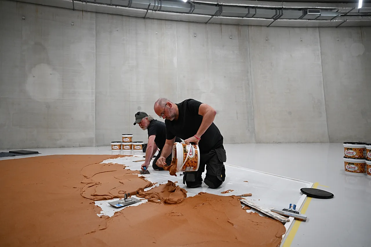 A munkások földimogyoróvajat kentek a padlóra, hogy újra létrehozzák a "Peanut Butter Floor"-t Wim T. Schippers holland művész előtt tisztelegve